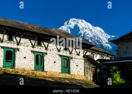 Ein Bauernhaus des historischen Dorfes mit der Berge Annapurna Süd in der Ferne Stockfoto