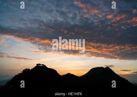 Schöne rote Wolken über zwei Hügel bei Sonnenuntergang Stockfoto