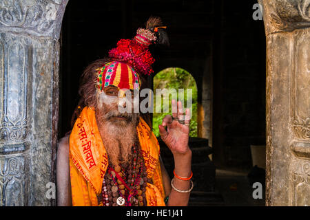 Portrait eines Sadhu, Heiliger Mann, sitzt an einem kleinen Heiligtum in Pashupatinath Tempel am Ufer des Bagmati Fluss Stockfoto