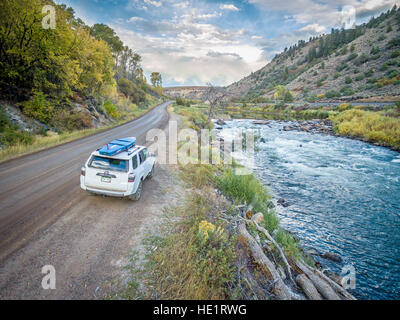 BURNS, CO, USA - 28. September 2016: Toyota 4Runner SUV (2016 Trail Edition) mit einem Paddleboard am Ufer des Colorado River in Herbstfarben. Stockfoto