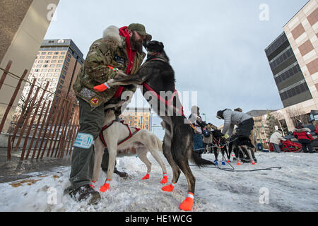 Matt Berth gibt einen Kuss, eine Schlacht Dawgs Schlittenhunde vor der feierlichen Beginn des Iditarod in Anchorage, Alaska, 5. März 2016. Schlacht Dawgs ist eine Organisation, die Verwundeten Krieger Veteranen mit therapeutischen und spannende Erlebnisse in Alaska durch die majestätische Heilkraft der Schlittenhunde befähigt. /Master Sgt. Brian Ferguson Stockfoto