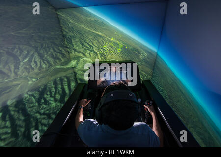 Zach Demers, ein Raumfahrt-Ingenieur, zeigt die automatische Boden Kollision Vermeidung System Auto GCAS in einer f-16-Flugsimulator an der Air Force Research Laboratory, Wright-Patterson Air Force Base in Ohio, April 18. Auto-GCAS, die ständig vergleicht das Flugzeug Geschwindigkeit und Position, um eine digitale topographische Karte und wird automatisch kontrollieren, wenn sie eine bevorstehende Boden Kollision feststellt, wird die Rettung von vier Piloten gutgeschrieben. /Master Sgt. Brian Ferguson Stockfoto