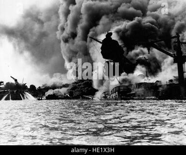 USS Arizona BB-39 versenkt und brennen wütend, 7. Dezember 1941. Ihre vorderen Magazine hatte explodiert, wenn sie durch eine japanische Bombe getroffen wurde. Auf der linken Seite spielen Männer auf dem Heck der USS Tennessee BB-43 Feuerwehrschläuchen auf dem Wasser, brennendes Öl Weg von ihrem Schiff offiziellen US Navy fotografieren, jetzt in den Sammlungen der National Archives zu zwingen. Stockfoto