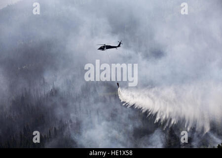 Ein Alaska Army National Guard UH-60 Black Hawk vom 1. Bataillon, 207. Aviation Regiment fällt ungefähr 700 Gallonen Wasser aus einem ÒBambi BucketÓ auf die Stetson-Creek-Feuer in der Nähe von Cooper Landing, Alaska, 17. Juni 2015. Zwei Black Hawks flog insgesamt 200 Eimer Missionen, dumping mehr als 144.000 Gallonen Wasser auf dem 300 Hektar großen Stetson Creek Feuer auf der Kenai-Halbinsel. US Army National Guard Foto/Sgt. Balinda OÕNeal Alaska Army National Guard Stockfoto