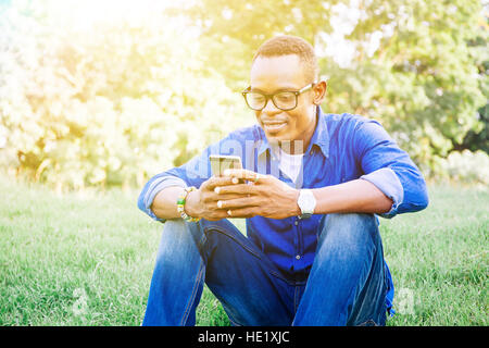 Afrikanische amerikanische Mann mit Handy im park Stockfoto