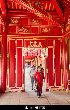 Vietnamesische Touristen spazieren in einer offenen Galerie in der Khon Thai Residence (Queen's Private Apartment). Imperial City, Hue, Vietnam. Stockfoto