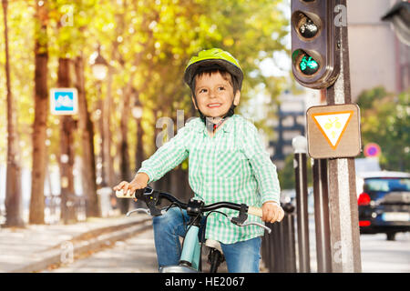 Netter Junge mit seinem Fahrrad auf grünes Signal der Lichter Stockfoto