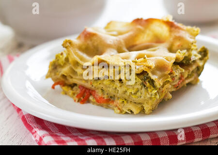 Vegane Lasagne mit Wirsing, Tofu und Paprika serviert auf weißen Teller Stockfoto