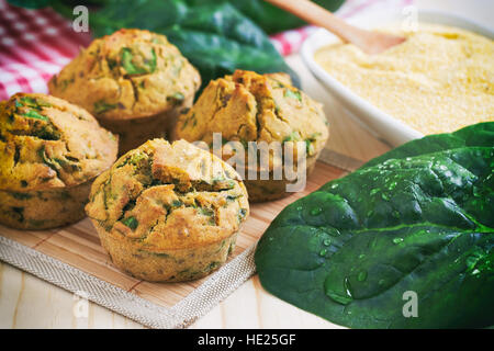 Vegane Muffins mit Spinat und Maismehl auf hölzernen Hintergrund Stockfoto