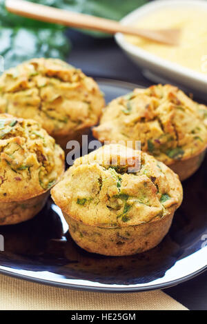 Vegane Muffins mit Spinat und Maismehl serviert auf schwarzem Teller Stockfoto