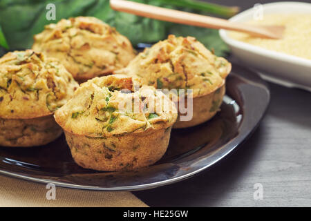 Vegane Muffins mit Spinat und Maismehl serviert auf schwarzem Teller Stockfoto