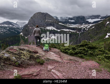 Frau schaut über Grinnell Lake an bewölkten Tag Stockfoto