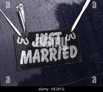 Just Married Schild hängen auf der Rückseite des grauen Oldtimer Hochzeitsauto im Regen. Stockfoto