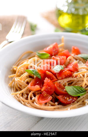 Vollkorn-Spaghetti mit Tomaten garniert mit Basilikum Blätter Stockfoto