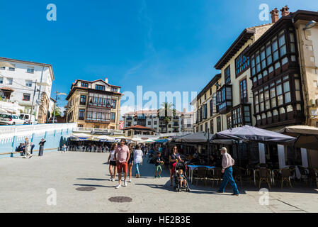 Restaurant und Bar-Terrassen mit Passanten auf der Straße in dem mittelalterlichen Dorf von Comillas in Kantabrien, Spanien Stockfoto