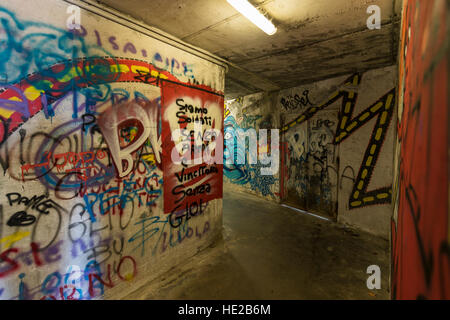 Graffiti in einer unter durchlaufen die Stadtmauern, Volterra, Toskana, Italien. Stockfoto