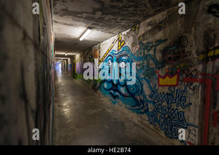 Graffiti in einer unter durchlaufen die Stadtmauern, Volterra, Toskana, Italien. Stockfoto