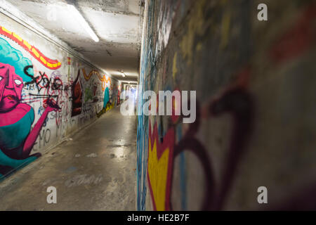 Graffiti in einer unter durchlaufen die Stadtmauern, Volterra, Toskana, Italien. Stockfoto