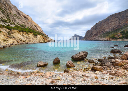 Steile Klippen oberhalb einer Bucht mit felsigen Strand Meer Stockfoto