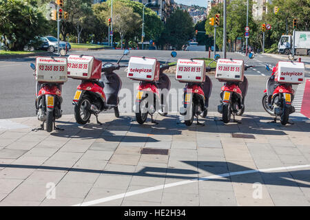 Eine Reihe von Telepizza Motoscooters geparkt auf einem Bürgersteig in Barcelona, Spanien mit ihrer Lieferung-Boxen auf dem Rücken befestigt. Stockfoto