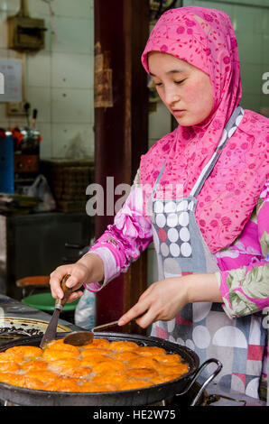 Hui uigurischen Frau bereitet Essen Braten Nang flache Brot muslimischen Viertel Markt Xian, China. Stockfoto