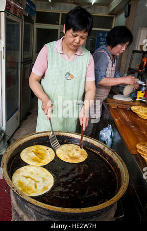 Hui uigurischen Frau bereitet Essen Braten Nang flache Brot muslimischen Viertel Markt Xian, China. Stockfoto