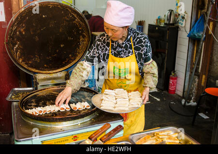 Hui uigurischen Frau Vorbereitung Braten Nang Fladenbrot muslimischen Viertel Lebensmittelmarkt Xian, China. Stockfoto