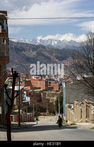 Ein Silhoueete einer Frau auf den Straßen von La Paz, Bolivien, Illimani und verschneiten Weißenberger Gipfel der Cordillera Real in der Ferne Stockfoto