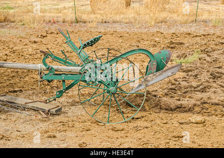 Antike Reiten Pflug Pflügen einen Garten wird von einem Team von zwei Pferden gezogen. Stockfoto