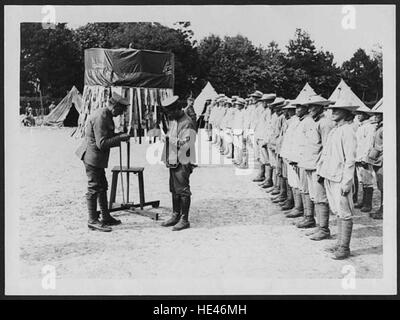 Das Bild zeigt eine Szene aus einem chinesischen Arbeitslager in Frankreich während einer vergangenen Zeit, wahrscheinlich im frühen 20. Jahrhundert. Es zeigt, dass Arbeiter zum namentlichen Aufruf aufgerufen werden, eine historische Darstellung des Lebens in Arbeitslagern während dieser Zeit. Stockfoto
