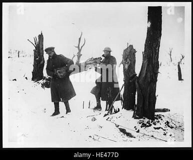 Dieses historische Bild zeigt Individuen, die einen Holzstamm für ein Lagerfeuer einbringen, was das tägliche Leben in einer vergangenen Zeit symbolisiert. Das Foto zeigt die Einfachheit und harte Arbeit der Vergangenheit und zeigt frühe menschliche Überlebenspraktiken auf. Stockfoto
