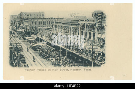 Ein historisches Bild einer Parade auf der Main Street in Houston, Texas, das das soziale Leben und die Geschäftsgebäude der Stadt in einer früheren Ära einfängt. Stockfoto
