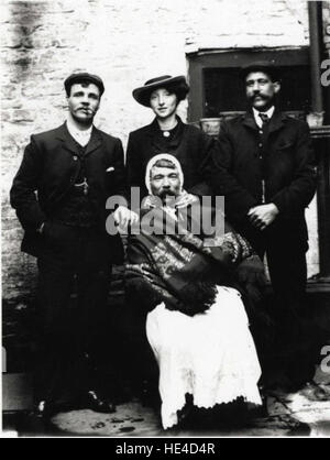 Gruppe mit Mann gekleidet in der Kleidung der Frau um 1900 (Archiv Stockfoto