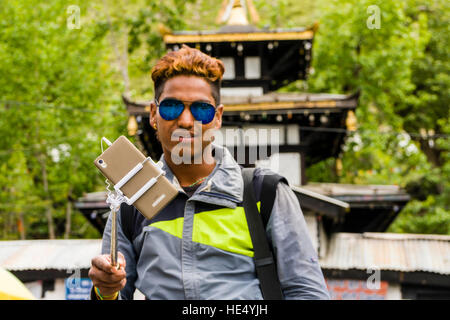 Ein junger nepali Mann nimmt eine selfie vor dem Tempel Stockfoto