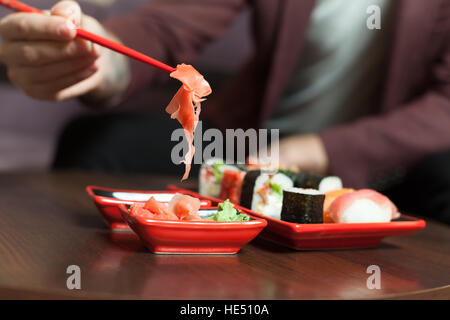 Halten Sie Ingwer mit Stäbchen Stockfoto