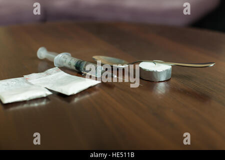 Medikament, Löffel und Spritze auf einem Tisch Stockfoto