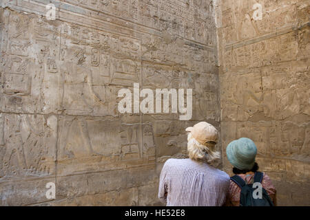 Zwei Touristen, die gerne an den Hieroglyphen in der Amun-Tempel, Luxor-Tempel, Luxor, Nil Senke, Ägypten, Afrika Stockfoto