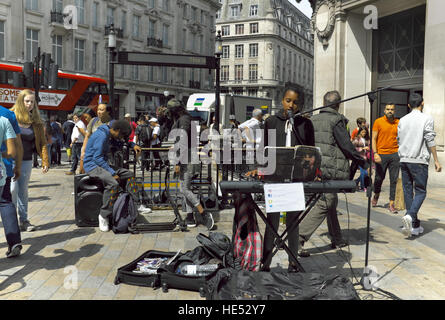 Eine Solo Frau Straßenmusiker auf einer belebten Straße Ecke in London, England-Gesang für Tipps. Stockfoto