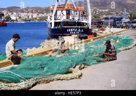 Fischer reparieren ihre Netze im Hafen von Agios Nikolaos auf der griechischen Insel Kreta Stockfoto