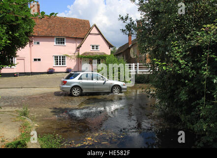 Auto, das durch eine Furt im Fluss auf der anderen Straßenseite im Dorf Kersey in Constable Land Suffolk England Stockfoto