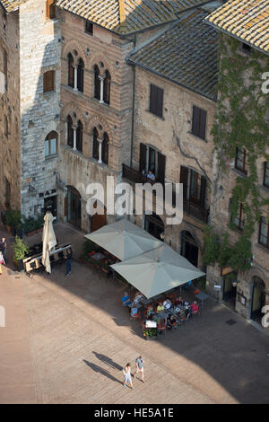 Piazza Della Cisterna mit Touristen beschäftigt, wie vom Torre Grossa gesehen. San Gimignano, Toskana, Italien. Stockfoto