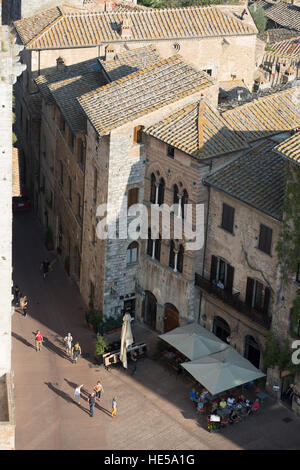 Piazza Della Cisterna mit Touristen beschäftigt, wie vom Torre Grossa gesehen. San Gimignano, Toskana, Italien. Stockfoto