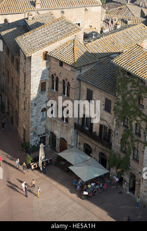 Piazza Della Cisterna mit Touristen beschäftigt, wie vom Torre Grossa gesehen. San Gimignano, Toskana, Italien. Stockfoto