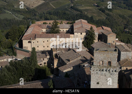 Torre Rognosa aka Der Clock Tower mit Blick auf die Piazza Della Cisterna vom Torre Grossa gesehen. Castello im Hintergrund. Stockfoto