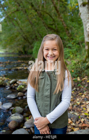 Junge Mädchen in eine grüne Weste posieren für ein Porträt der Lebensstil im Freien an den Ufern des McKenzie River in Oregon. Stockfoto