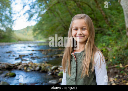 Junge Mädchen in eine grüne Weste posieren für ein Porträt der Lebensstil im Freien an den Ufern des McKenzie River in Oregon. Stockfoto