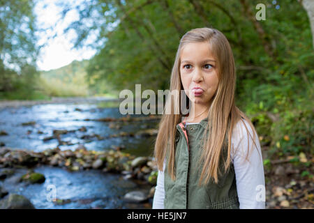 Junge Mädchen in eine grüne Weste posieren für ein Porträt der Lebensstil im Freien an den Ufern des McKenzie River in Oregon. Stockfoto