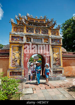 Touristen zu Fuß durch Eingang Tor aufgehängt Mieu Tempel. Imperial City (Zitadelle), Hue, Vietnam. Stockfoto