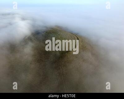 Nebel hüllt die Eisenzeit Fort auf Mount Caburn, Lewes, in der South Downs National Park Stockfoto