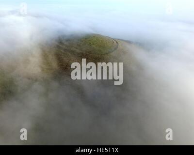 Nebel hüllt die Eisenzeit Fort auf Mount Caburn, Lewes, in der South Downs National Park Stockfoto